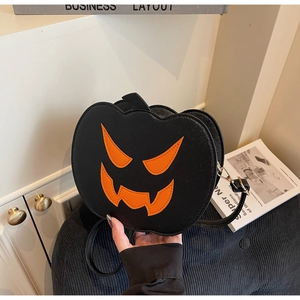 Detail of black pumpkin crossbody bag with orange jack-o-lantern face for Halloween