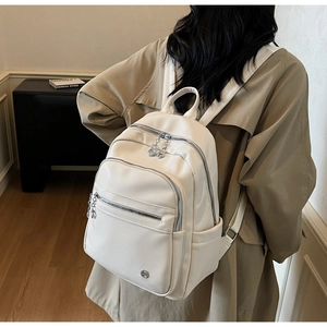 Detailed back view of white lychee texture leather backpack showing multi-pocket design