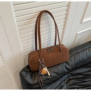 Detailansicht braune Wildleder-Schultertasche mit Reißverschluss und Baseball-Anhänger
