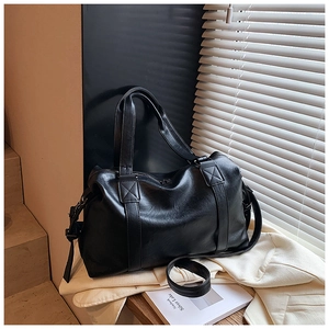 Detail of black faux leather Boston bag showing reinforced stitching and soft texture
