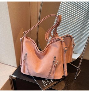 Detail of dusty pink tote bag showing star-shaped zipper and soft matte texture