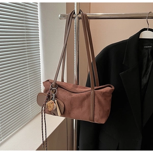 Détail du sac à bandoulière en daim marron vintage avec charms feuilles et fini mat
