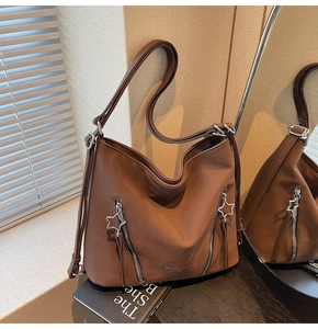 Detail of caramel brown PU leather tote bag with silver star-shaped zipper pulls