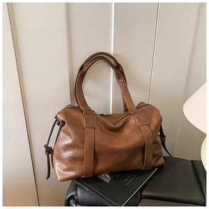 Detail of retro brown leather Boston bag with oily texture and dual zipper closure