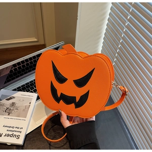Detailed view of pumpkin-shaped crossbody bag with Jack-o'-lantern face and adjustable strap