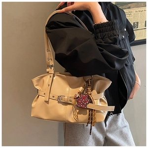 Gros plan sur sac fourre-tout beige plissé avec boucle et charme d'ours léopard