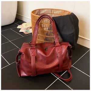 Detail view of the soft faux leather texture and reinforced handles of the dark red tote bag