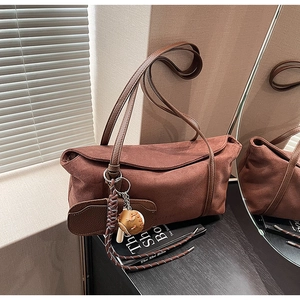 Vue détaillée du sac sous le bras en daim marron avec mini-bourse et pendentif de baseball