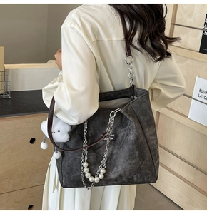 Detail der dunkelgrauen matten Shopper-Tasche mit Silberkette Perlen und Plüsch-Anhänger