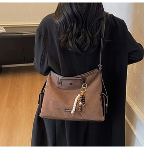 Close-up of matte suede vintage hobo bag with fashion label and beaded detail
