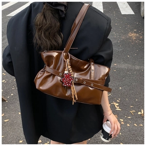 Vue de rue d'un sac cabas marron en similicuir plissé avec un charm ours imprimé léopard