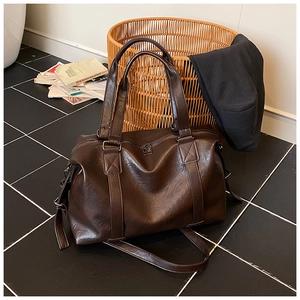 Close-up of soft brown leather texture and buckle detail on this large tote bag