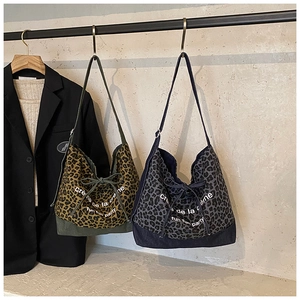 Detail of leopard print tote bags in brown and grey denim with drawstring closure