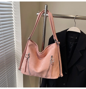 Detail of pink hobo bag with star-shaped zippers and spacious minimalist design