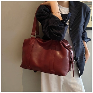 Detailed view of dark red soft leather tote bag with wide handles and side D-rings