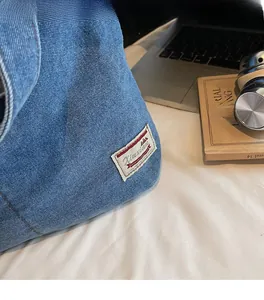 Detail of blue denim fabric texture and vintage Xiuxian label on casual shoulder bag