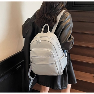 Litchi texture faux leather backpack detail showing large capacity and side pocket on stairs