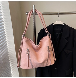 Detail of pink hobo tote bag featuring star zipper pulls and versatile shoulder straps