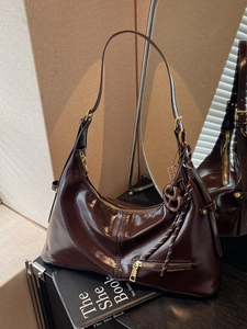 Sac hobo rétro marron foncé brillant avec pendentif bretzel dans un décor intérieur élégant