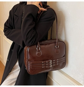 Detail of vintage dark brown tote bag featuring three silver decorative buckles and straps