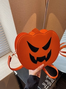 Handheld Halloween pumpkin crossbody bag with textured orange finish and funny face detail