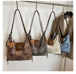 Vue détaillée de quatre sacs cabas texturés avec rabats en cuir et breloque ours