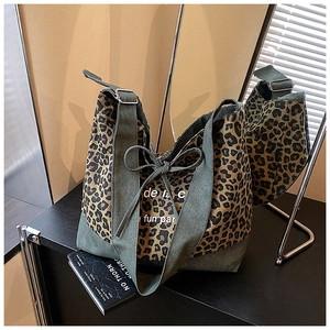 Close-up of leopard print tote bag featuring green canvas trim and bow decoration