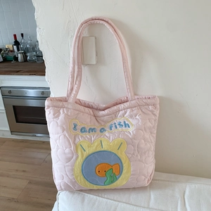 Detail of pink quilted heart tote bag with I am a fish cartoon patch embroidery