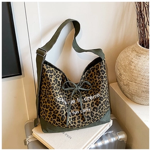Detail of leopard print canvas tote bag with green accents and bow drawstring decoration