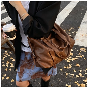 Chic brown PU leather tote bag shown in an autumn street scene with fallen ginkgo leaves