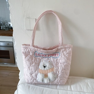 Detail of pink quilted tote bag featuring heart patterns and lucky puppy plush embroidery