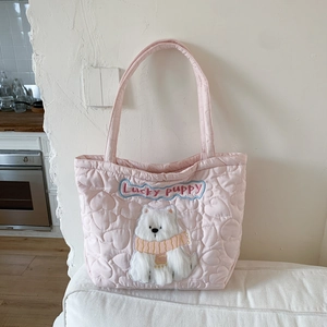 Detail of pink quilted tote bag featuring lucky puppy embroidery and heart stitching