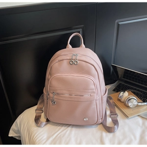Detailed macro view of the pink lychee-patterned leather texture and silver zipper of this backpack
