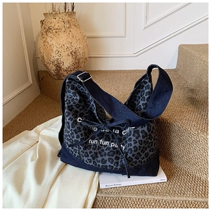 Detail of leopard print denim tote bag with drawstring bow and metal buckle strap