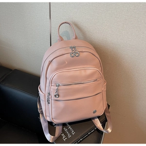 Close-up of pink lychee grain PU leather backpack with multiple zipper compartments