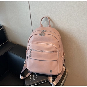 Detail of light pink pebble leather backpack with silver zippers and side pockets