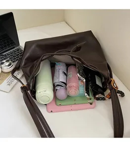 Interior of brown faux leather bucket bag showing large capacity for laptop and daily items