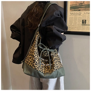 Detail of leopard print tote bag with green canvas base and stylish drawstring closure
