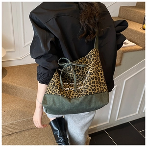 Detail of leopard print patchwork tote bag with drawstring bow and creme text print
