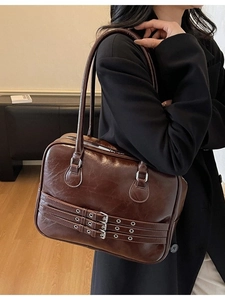 Deep brown retro tote bag in glossy leather with decorative triple buckle straps