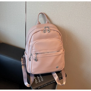 Macro detail of pink lychee textured leather backpack with silver zippers and metal logo