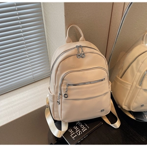 Detail of off-white lychee grain leather backpack with silver zippers and metal logo