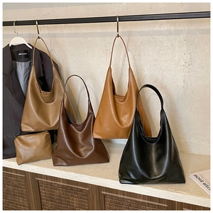 Détail de grands sacs fourre-tout en cuir noir et marron avec petites pochettes assorties
