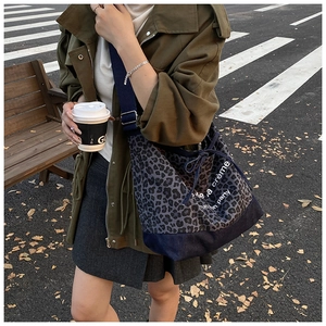 Macro shot of leopard print canvas bag with drawstring detail and blue strap