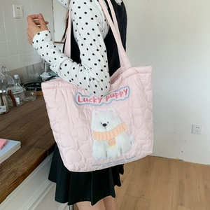 Detail of light pink quilted tote bag with cute plush puppy embroidery and heart pattern