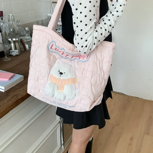 Detail of pink heart-quilted canvas tote bag featuring a plush lucky puppy patch