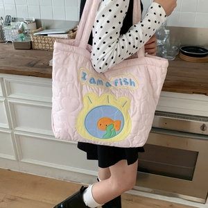 Detail of pink quilted tote bag with fish embroidery and I am a fish text design