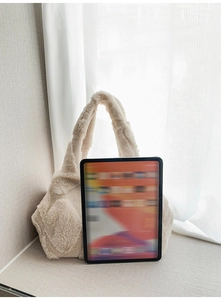 Detail of soft cream faux fur tote bag showing plush texture against a clean background