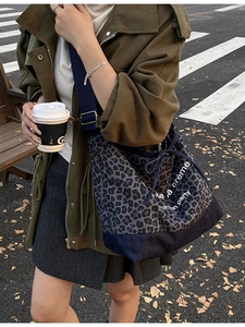 Leopard print denim tote bag with drawstring closure and wide blue shoulder strap