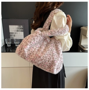 Dettaglio della borsa tote in peluche leopardata portata a spalla in un caffè moderno